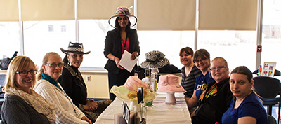 Attendees learn about the importance of women’s hats and headdresses during a Women's History Month presentation
