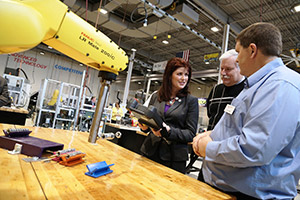 Gateway Automated Manufacturing instructor JD Jones demonstrates robotics equipment to Lt. Gov. Rebecca Kleefisch