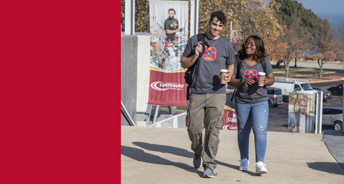 Two students walking together on campus in the fall