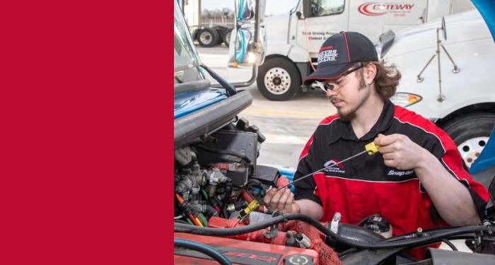 Gateway Diesel Equipment Mechanic student checks the oil on a diesel engine.