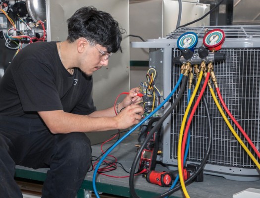 HVAC student working on air conditioning unit