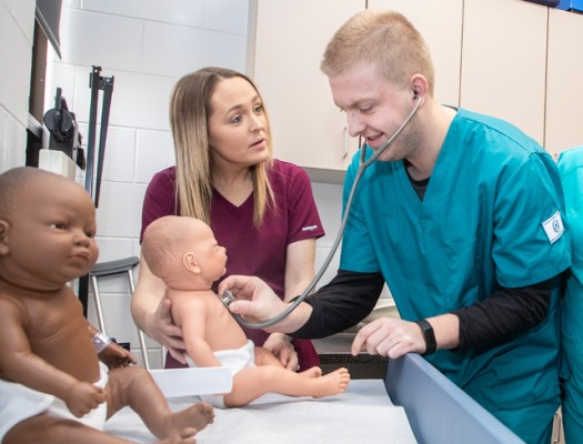 Medical Assistant student learning to listen to heart with stethoscope