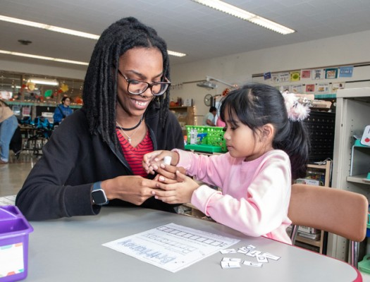 Gateway Foundations of Teacher Education student interacts with a child in a classroom setting.