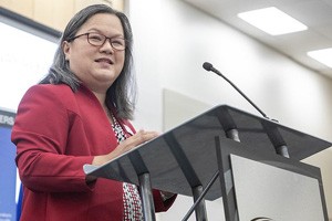 Dr. Tran addresses an audience from a podium