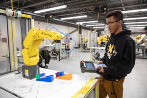 Gateway Advanced-Manufacturing student using a robotic arm in a lab.