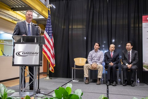 Gateway Technical College President and CEO Bryan Albrecht is speaking at the podium during the SC Johnson iMET Center expansion and renovation groundbreaking event Oct. 22. Seated (l-r): Governor Scott Walker; Fisk Johnson, SC Johnson chairman and CEO; Alan Yeung, Foxconn director of US Strategic Initiatives.