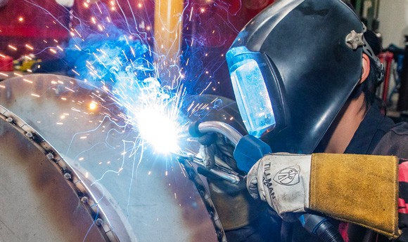 Gateway welding student in headgear with sparks