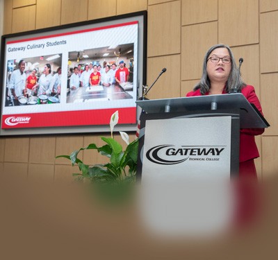 Dr. Veronique Tran speaks at a podium at the Inauguration Event