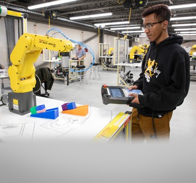 Gateway Advanced Manufacturing student using a robotic arm in a lab.